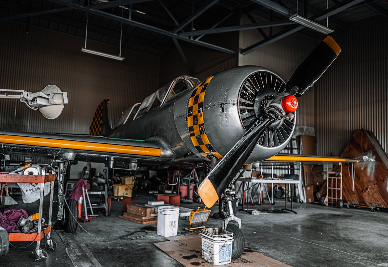 Old fashioned gray propeller jet parked for maintenance in modern spacious air shed